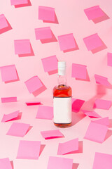 Bottle of whiskey among empty pink sticky notes. Minimal overwhelmed concept.