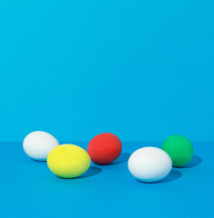 Easter eggs on bold blue background with empty space for text. Minimal Easter concept.