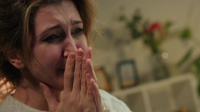 Crying woman close-up, portrait of scared female person in living room, feeling anger and stress, bad mood. Family problems, aggressive emotional wife having fear and fright. 