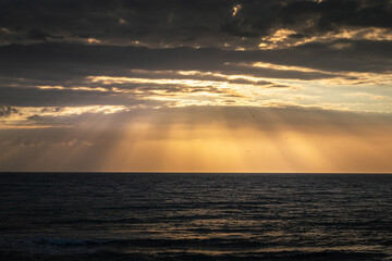 Obraz premium Spain beach at sunrise with large rocks in the sand.