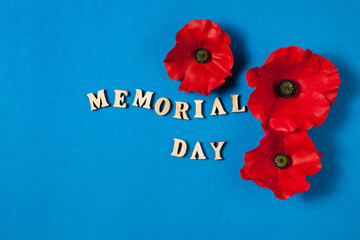 Text Memorial Day and a poppy flowers on blue background