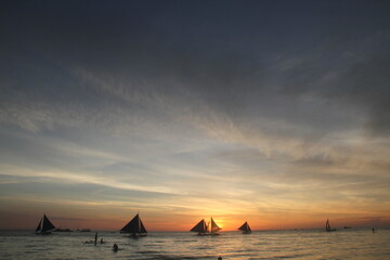 Silhouette of sailing boats during sunset in Boracay, Philippines. 