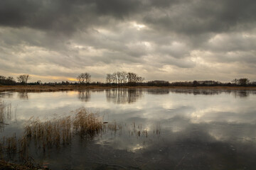 Dark clouds over the frozen lake, winter view