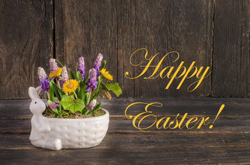 Easter card, composition with rabbit and spring flowers on a wooden background