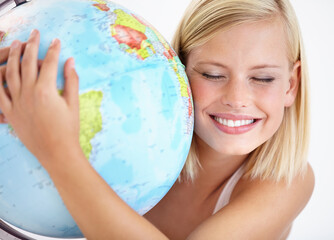 Our planet is amazing. A pretty young woman hugging a globe of the earth.
