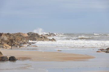 Rocks on the beach, ocean, waves, blue sky 