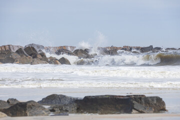 Rocks on the beach, breakwater, ocean, waves, blue sky 