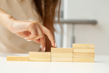 Women fingers climb up wooden block closeup