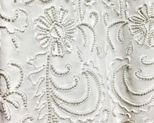 Close-up detail of white and ivory beaded wedding gown