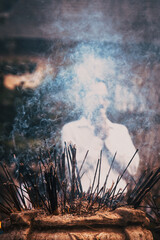 burning incense sticks and people praying