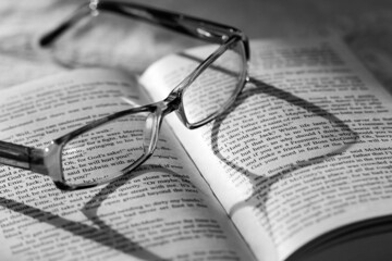 Eyeglasses Casting Shadow on Pages of Open Book