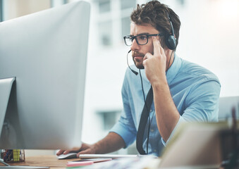 Trust him to find the answer. Shot of a young man working in a call center.