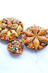 Nowruz festive table. arabic dessert baklava, sweets, nuts, dry fruits on abstract marble background. Traditional celebration of spring equinox in March, Nowruz Holiday. top view