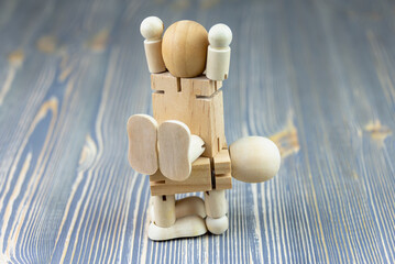 Wooden figure of a man. Concept: a person carries another person.