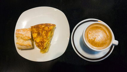 cup of coffee latte accompanied by a potato omelette skewer and a piece of bread