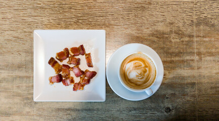 cup of coffee latte  accompanied by torrezno skewer