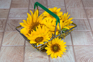 Beautiful yellow flowers in a basket on a checkered table.