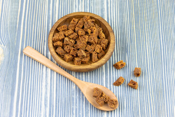 Brown croutons (cubes) in a wooden bowl.
