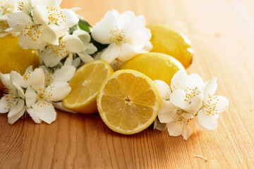 Flowering jasmine and lemons on a wooden background.