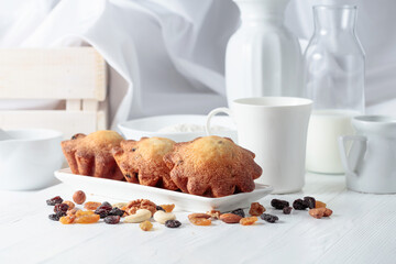 Cupcakes with nuts and raisins on a kitchen table.
