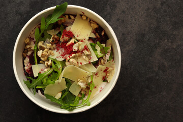 Vegan food. Breakfast oatmeal porridge with cherries, parmesan, arugula and nuts on a dark background in an eco paper box. Healthy balanced food. Top view, overhead, banner