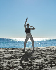 A selective color photo of a woman dancing in the beach