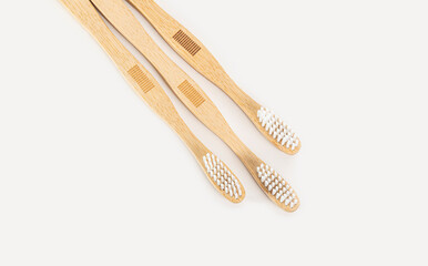Three bamboo toothbrushes on a light background. A zero-waste or low-waste alternative to plastic.