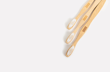 Three bamboo toothbrushes on a light background. A zero-waste or low-waste alternative to plastic.