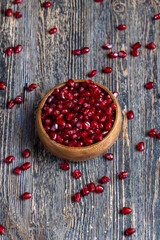 scattered pomegranate seeds on a wooden board