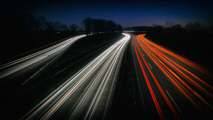 Autobahn bei Nacht mit Lichtspuren von vielen Autos