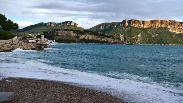 View of small pebble beach Plage du Bestouan on the mediterranean coast at town Cassis, French Riviera on cloudy day in autumn season.