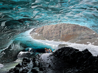 Unrecognizable tourists inside a glacier in Skaftafell National Park, in Iceland. The glacier of Vatnajökull is a huge glacier at the southern part of Iceland, Europe.