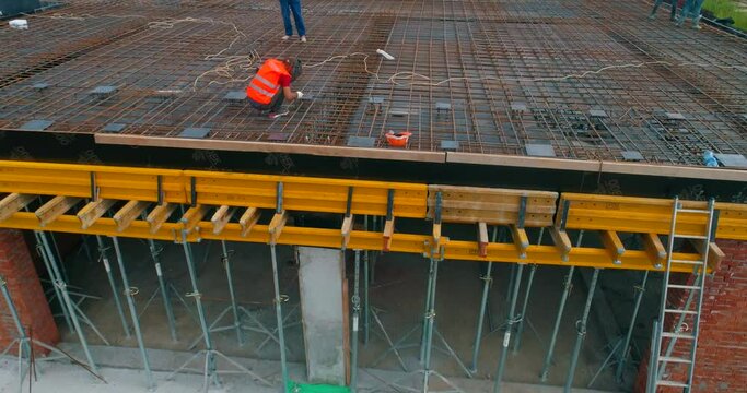 Builders make formwork at the construction site of a new stadium. Construction process of a modern football stadium. Aerial view of reinforced concrete construction