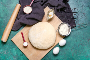 Fototapeta na wymiar Raw dough with ingredients on color background