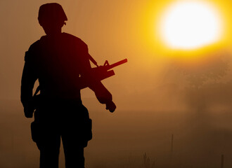 Shadow of a soldier with a gun in the heat weather and with the hot sun