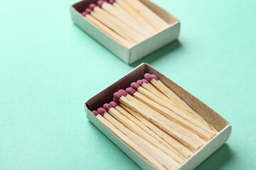 Boxes with whole wooden matchsticks on color background, closeup