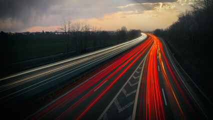 Autobahn mit Lichtspuren von vielen Autos in der Morgendämmerung