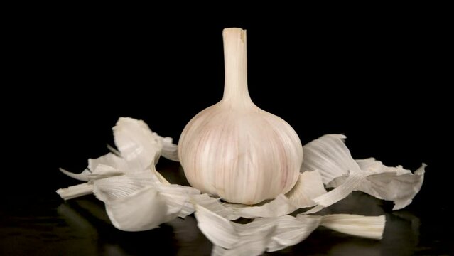 head of garlic rotates on a black background, close-up 