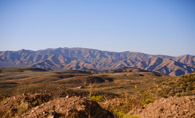 Golden sunset light shining on foothills of mountain range in Idaho
