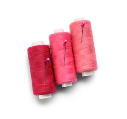 Pink sewing threads on white background