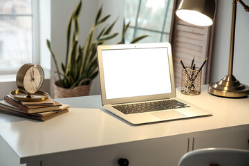 Modern laptop and glowing lamp on table in room