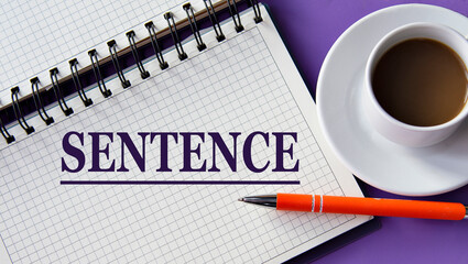 Fototapeta na wymiar SENTENCE - word in a white notebook on a purple background with a cup of coffee