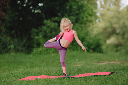 A sporty girl does gymnastic exercises on a mat.A healthy lifestyle.