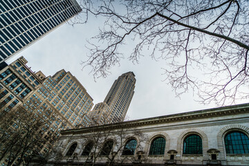 Low angle shot of tall buildings with trees in Bryant Park