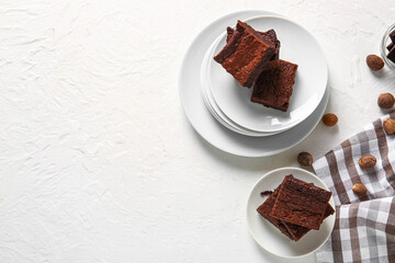 Plates with pieces of delicious chocolate brownie on light background