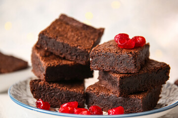 Plate with pieces of delicious chocolate brownie on light background, closeup