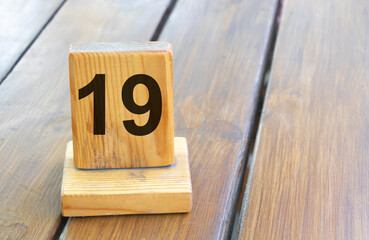 Wooden priority number 19 on a plank tab
