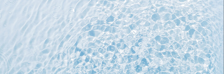Banner of blue water, clean and transparent background, surface with vibrations from drops, flat lay