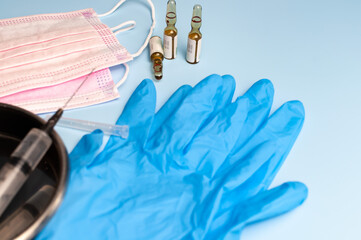 The syringe of injection with gloves and mask. Syringe with injection in a medical tray. The medical procedure.