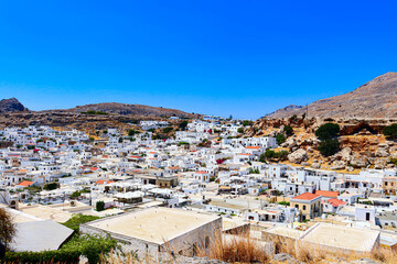 Aerial view of Whitewashed buildings of Lindos on Rhodes island in Greece with a sunny blue sky